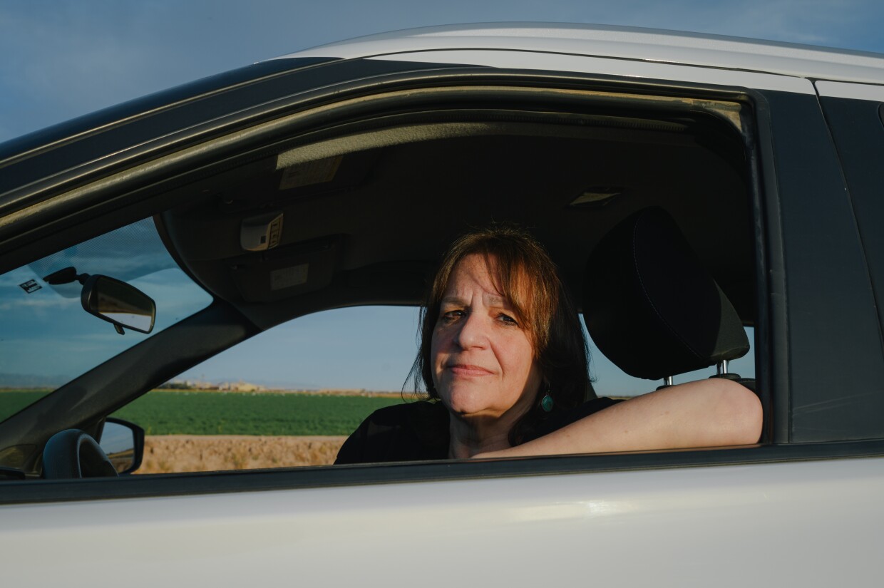 Wendy Miller, a public defender and wildlife photographer in Imperial County, sits for a portrait in her car near the south end of the Salton Sea in Calipatria, California. In 2014, Miller became interested in the region's thriving burrowing owl population and moved here to spend more time with them.