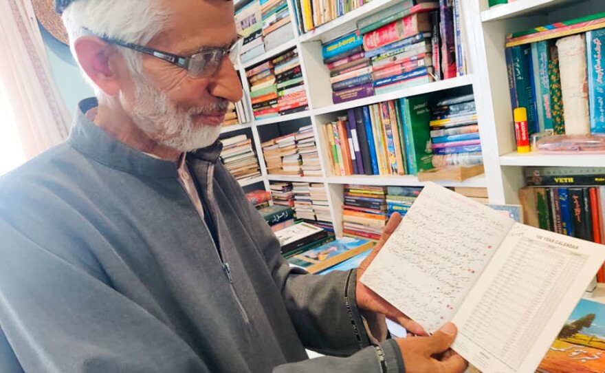 Zareef Ahmad looks at his notebook of tree notations in his home in Srinagar on May 11, 2022. He has planted hundreds of chinar trees over the years. "I have planted them in police stations, government offices and universities, where they can use its shade to cool off tensions," he says.