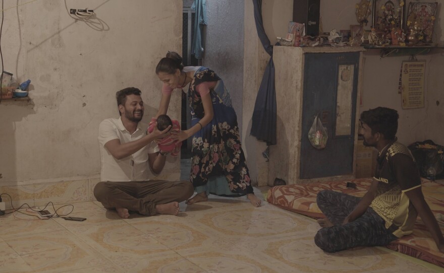 Devyani hands over baby to Ganesh as Rakesh looks on.