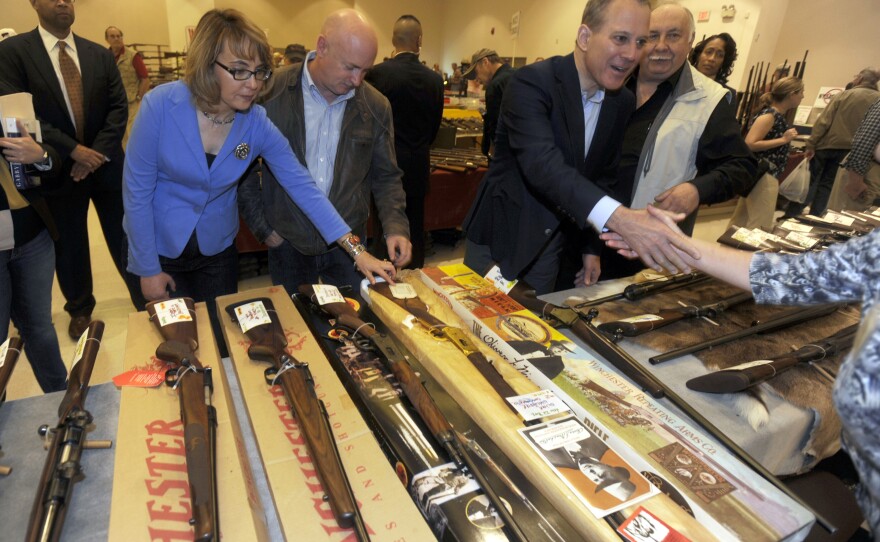 Former Rep. Gabby Giffords and her husband, Mark Kelly, at a gun show in Saratoga Springs, N.Y., in October. Giffords was shot in the head in a 2011 mass shooting in Tucson. She and Kelly have since founded a political action committee to push for tougher gun laws.