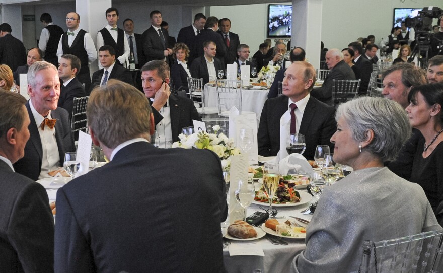 Russian President Vladimir Putin sits next to Flynn at an exhibition marking the 10th anniversary of RT (Russia Today) in Moscow on Dec. 10, 2015.