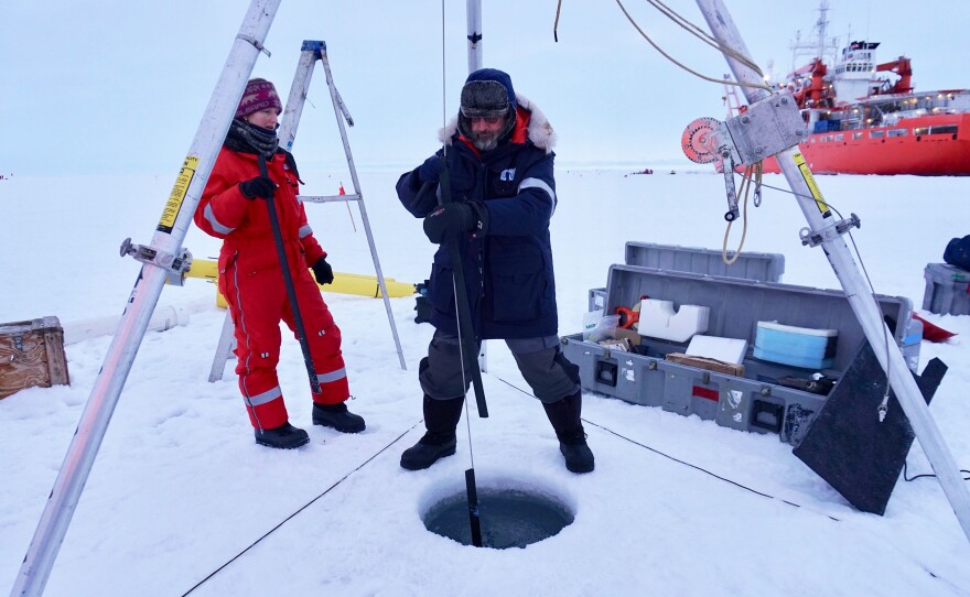 Tim Stanton installing a science buoy with the help of student Rosalie McKay. The buoy will measure heat, salt and momentum in the upper layer of the ocean over the course of a year.