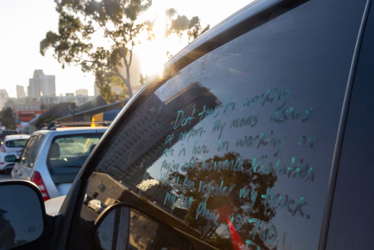 A note written in a parked car window in San Diego pleads with police to not tow the car, June 27, 2023.