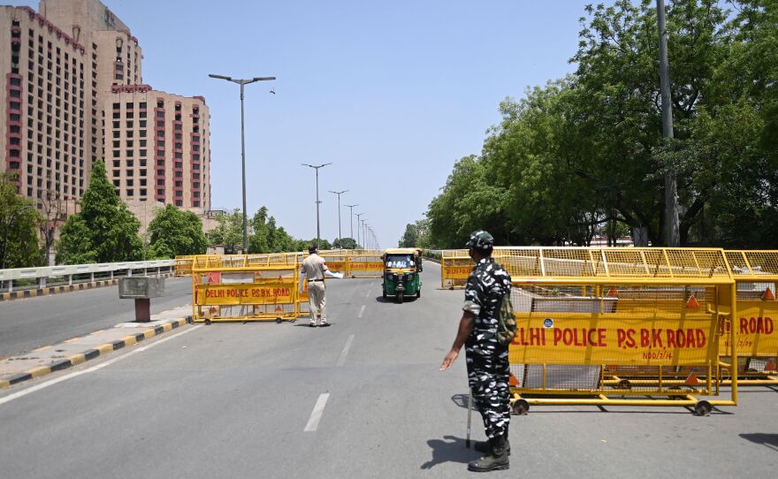 Police stop vehicles April 18 at a New Delhi checkpoint aimed at enforcing a weekend lockdown the government imposed in the wake of rising COVID-19 cases.