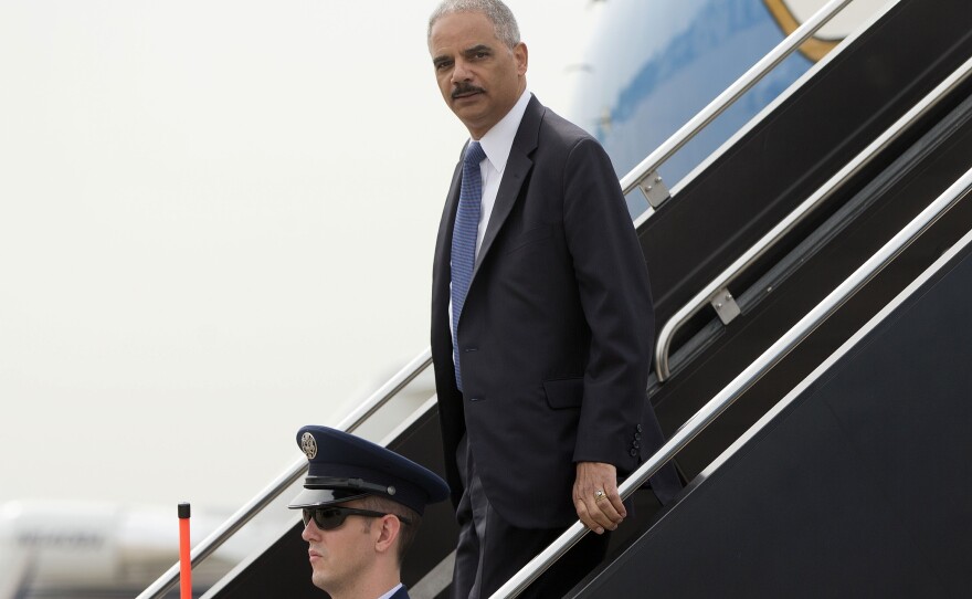 Attorney General Eric Holder arrives on a military aircraft at Lambert-St. Louis International Airport in St. Louis on Aug. 20. He was traveling to Ferguson, Mo., to check in on the federal government's investigation into the Aug. 9 shooting of 18-year-old Michael Brown by a police officer.