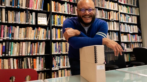 T.J. Tallie poses with a box of materials on Marti Mackey in the Lambda Archives of San Diego on Jan. 15, 2025.