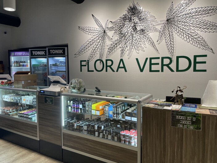 The inside of Flora Verde Dispensary in Vista where cannabis products are displayed and cannabis wire art is displayed on a wall behind their register. October 13, 2021.