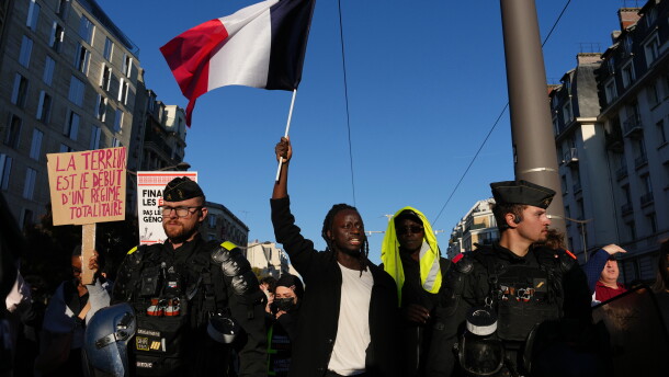 A demonstrator holds a French flag during a demonstration against rising living costs in Paris on Saturday.