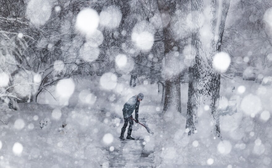 Kathy Gomez shovels her sidewalk on Sunday in Denver. Around 2,000 flights in and out of Denver have been canceled this weekend and highways around the state have been closed down as a winter storm pummels Colorado and neighboring states.