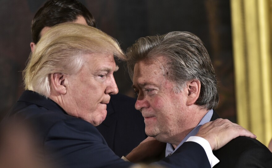President Donald Trump congratulates Stephen Bannon during the swearing-in of senior staff in the East Room of the White House on January 22, 2017.