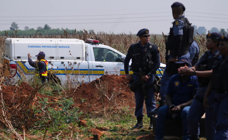 Forensic investigators work at the site where the body of a woman was discovered on the outskirts of Johannesburg, South Africa, Thursday, Sept. 17, 2026.