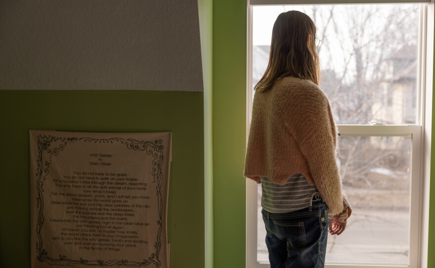 Elle poses for a portrait inside her Minneapolis home, where she says she has been surveilled by U.S. Immigration and Customs Enforcement agents during Operation Metro Surge.