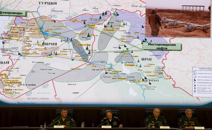 Russian Defence Ministry officials sit under a display showing the Turkish-Syrian border during a news conference Wednesday in Moscow.