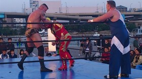 Marine Corps Sgt. Gaylon Summers, left, grapples with Azteca at an outdoor wrestling match in Fukuoka, Japan
