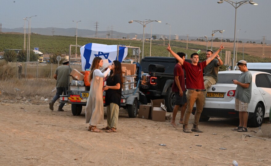 Young activists outside a gas station near Sderot, Israel, play music and pass out food to soldiers.