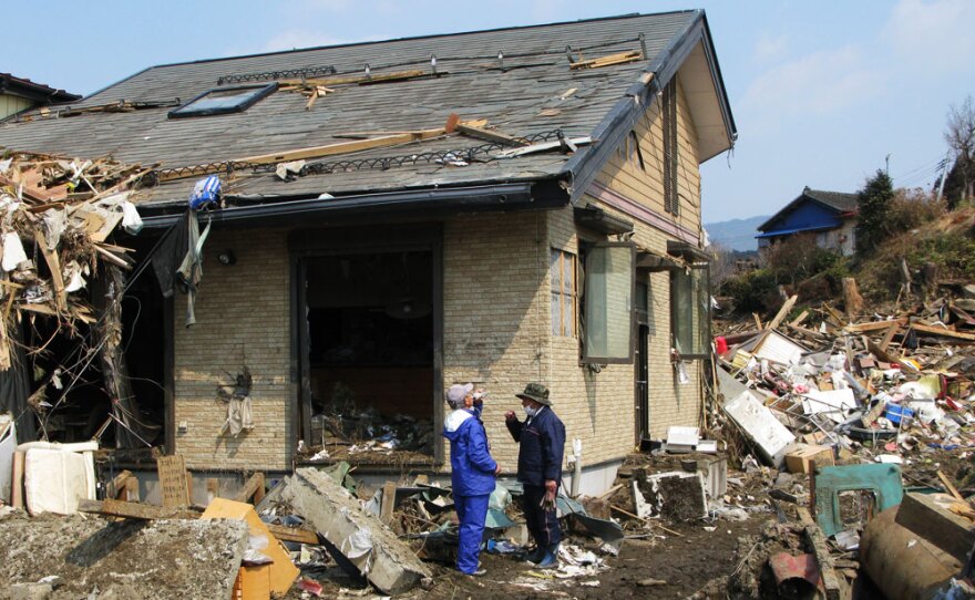 Noriaki Osaka (right) and his brother, Toshiaki, stand by the home where they found and removed the bodies of their sister and  100-year-old mother in Rikuzentakata.