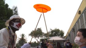 A performer with Fern Street Circus interacting with a child at Central Elementary in City Heights on Oct. 26, 2020.