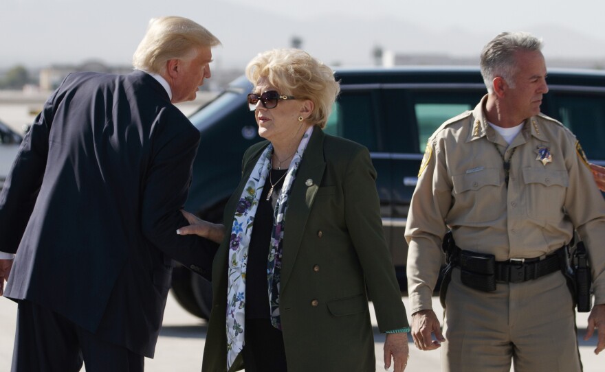 President Trump talks with Las Vegas Mayor Carolyn Goodman and Clark County Sheriff Joseph Lombardo (right) after arriving at Las Vegas McCarran International Airport on Wednesday to meet with victims and first responders of the mass shooting.