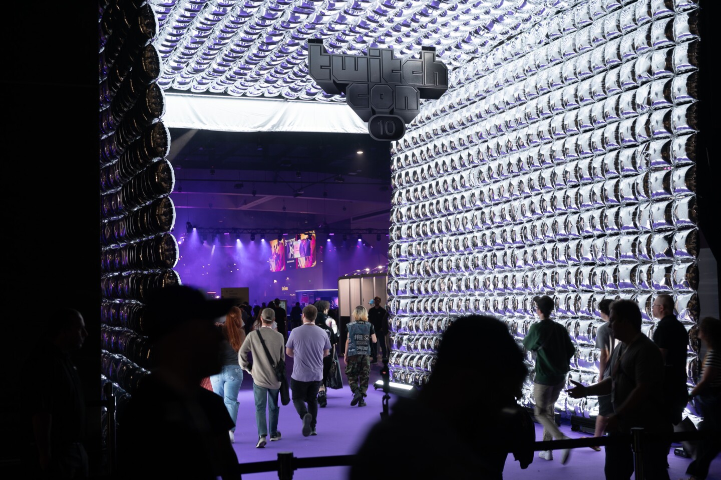 Attendees snap photos and take in the convention floor at TwitchCon in downtown San Diego on Oct. 17, 2025.