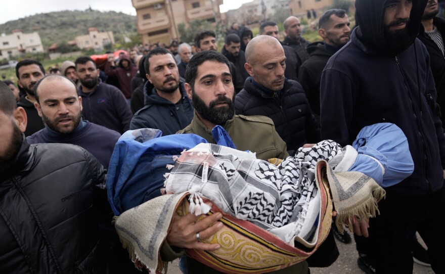 A Palestinian man carries Muhammad Bani Odeh, 5, at the funeral of four members of the Odeh family who were killed in their car by Israeli security forces during an army operation in Tammun, West Bank, Sunday, March 15, 2026.