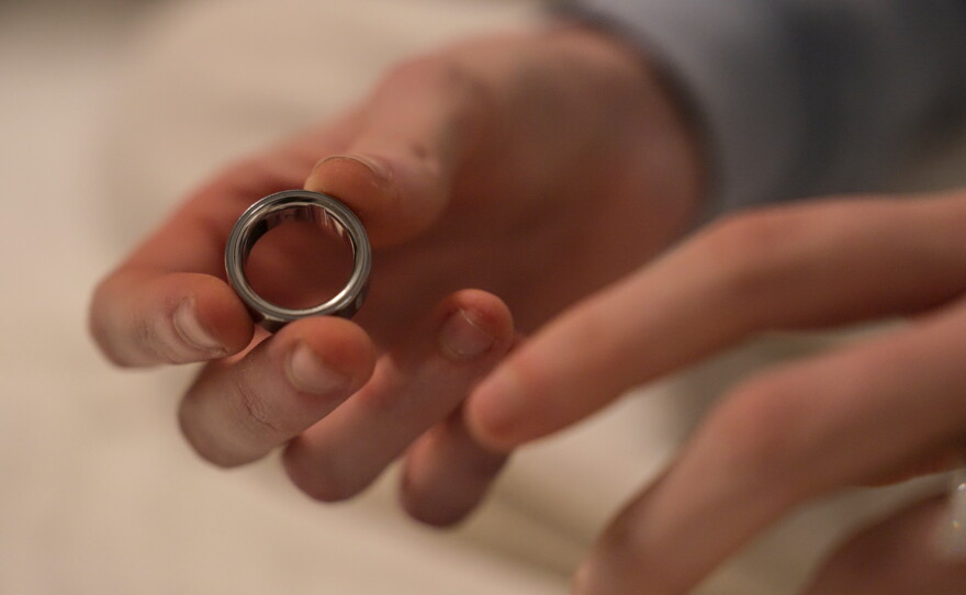 A woman puts on an Oura ring, a wearable health tracking device, whose maker is slated to go public in one of this year's blockbuster IPOs.