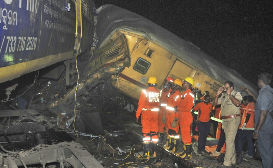 Rescuers and others stand after two passenger trains collided in Vizianagaram district, Andhra Pradesh state, India, Sunday, Oct.29, 2023.