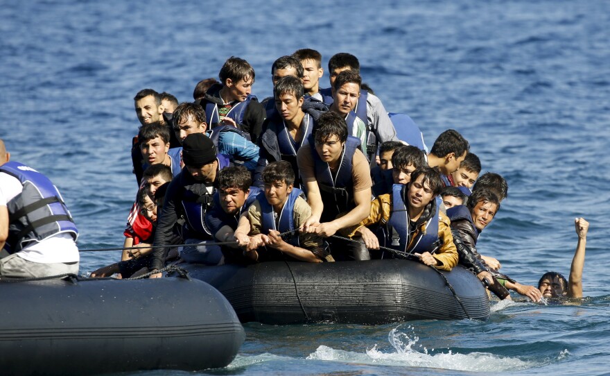 A dinghy with volunteer rescuers (left) tows a dinghy overcrowded with Afghan refugees that was drifting out of control between the Greek island of Lesbos and the Turkish coast on Saturday.