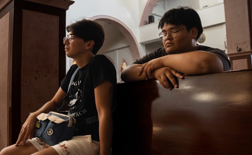 Bryan Vega and his brother Alexis pray in the Catedral de Nuestra Señora de Guadalupe on Aug. 6, 2024.