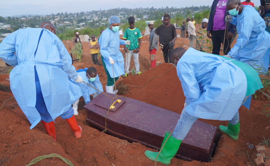 People dressed in protective gear lower into a grave the coffin containing the remains of 6-year-old Baudjo Baraka Jules, who died of Ebola, in Bunia, Ituri province, eastern Congo, Tuesday, Aug. 18, 2026.