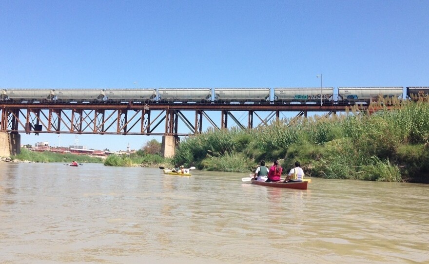 Kayakers head out on the Rio Grande River, toward one of the international bridges that connects Laredo, Texas, and the town of Nuevo Laredo in Mexico. Raw sewage and animal carcasses float in the water.