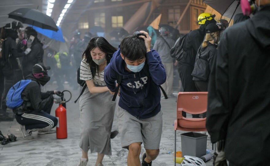 Protesters run for cover after riot police in Hong Kong on Nov. 18, 2019. Mass protests rocked the city in 2019 and 2020.