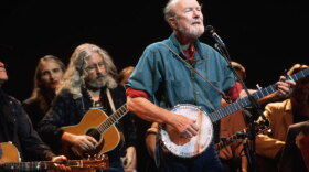 Folk music icon Pete Seeger plays the banjo and sings with Arlo Guthrie (back left) at the Woody Guthrie Tribute Concert at Severance Hall in Cleveland, September 1996.