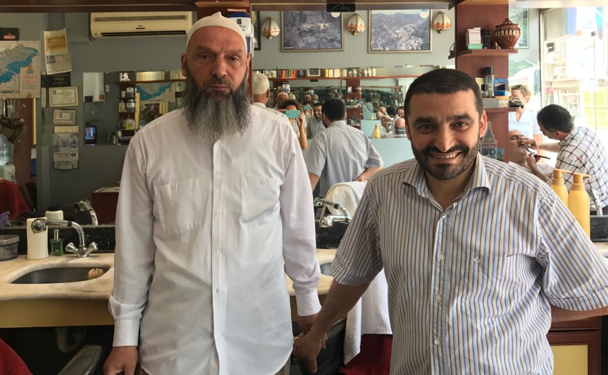 Suat Keceli, left, a retired stockroom worker, and his barber Yasar Ayhan pose in Ayhan's barber shop in Kasimpasa, the Istanbul neighborhood where President Recep Tayyip Erdoğan grew up. Keceli is a conservative Muslim who kept his daughter out of school when headscarves were banned in the classroom.