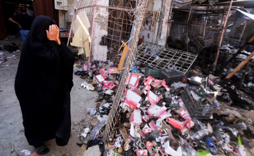 An Iraqi woman stands amid the debris following a suicide car bomb attack carried out by the Islamic State north of Baghdad, on July 18. The extremist group still holds much of western Iraq despite the U.S. air campaign that began a year ago.