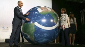Climate conference president Salaheddine Mezouar and French Environment Minister Segolene Royal, right, stand next to a globe during the opening session of the Climate Conference in Marrakech, Morocco, Nov. 7, 2016. 