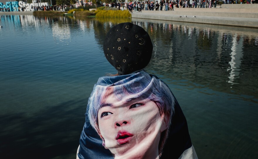 Tiffany Lui stands with a blanket of BTS member Jin before the concert. Lui spent her time handing out little BTS gift packs to other fans before the concert.