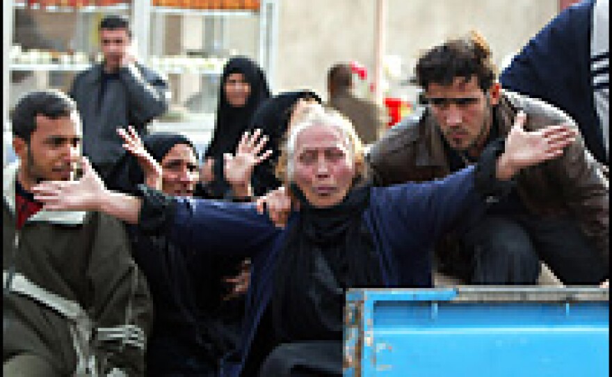 An Iraqi woman mourns next to the coffin of a relative in Baghdad on Feb. 4, 2007, one day after a suicide bomber blew up his Mercedes truck in central Baghdad's al-Sadriya district.