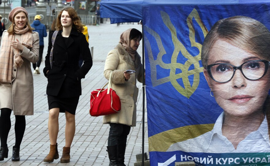 Passersby walk past a tent in support of former Prime Minister Yulia Tymoshenko in Kiev on March 26. None of the 39 presidential hopefuls are expected to win an outright majority in Sunday's vote, meaning a likely runoff.
