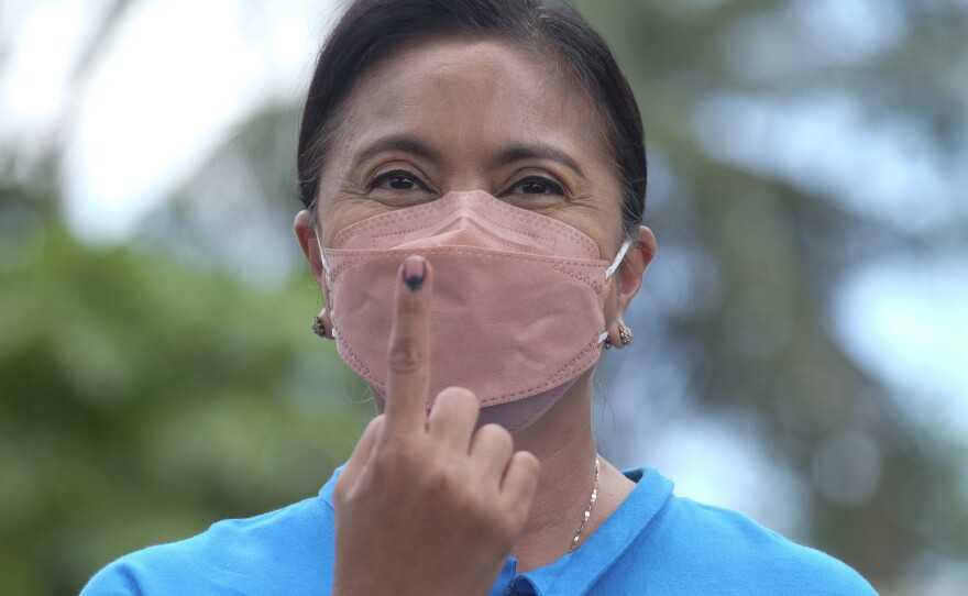 Presidential candidate and incumbent Vice President Leni Robredo shows the ink on her finger to mark that she has finished voting at a school used as a polling center in Camarines Sur, Philippines on Monday.