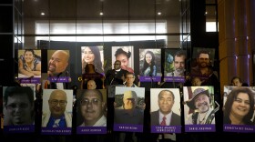In this Dec. 7, 2015, file photo, San Bernardino County employees hold up photos of the San Bernardino shooting victims during a candlelight vigil in San Bernardino, Calif. 