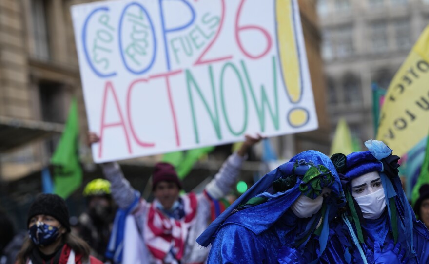 Activists protesting "greenwashing," in which a company or government appears to do more for the environment than it is, gather outside the JP Morgan premises near the COP26 U.N. Climate Summit.