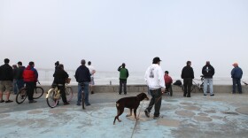 Crowds gather along the beach in Ocean Beach after the earthquake in Japan. 