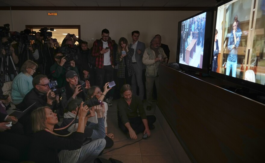 Journalists watch a TV screen broadcasting a hearing on <em>Wall Street Journal</em> reporter Evan Gershkovich's case from a courtroom at the Moscow City Court on April 18, 2023.