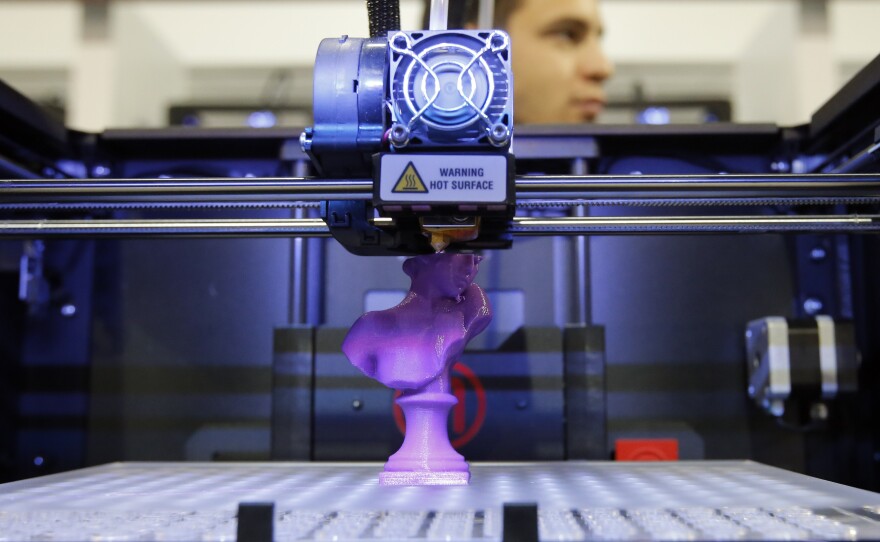 A 3-D desktop printer on display at the 2013 International Consumer Electronics Show in Las Vegas demonstrates how designs are translated into plastic objects.