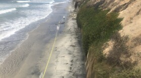 Police tape blocks off a section of beach in Encinitas where three women were killed when a cliff collapsed onto them, August 5, 2019.