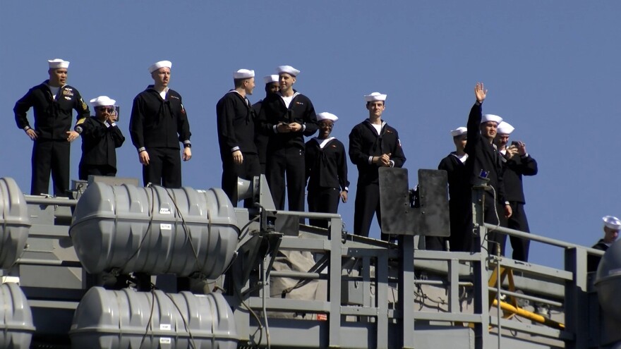 Sailors on board the USS Carl Vinson wave to family on their return to San Diego