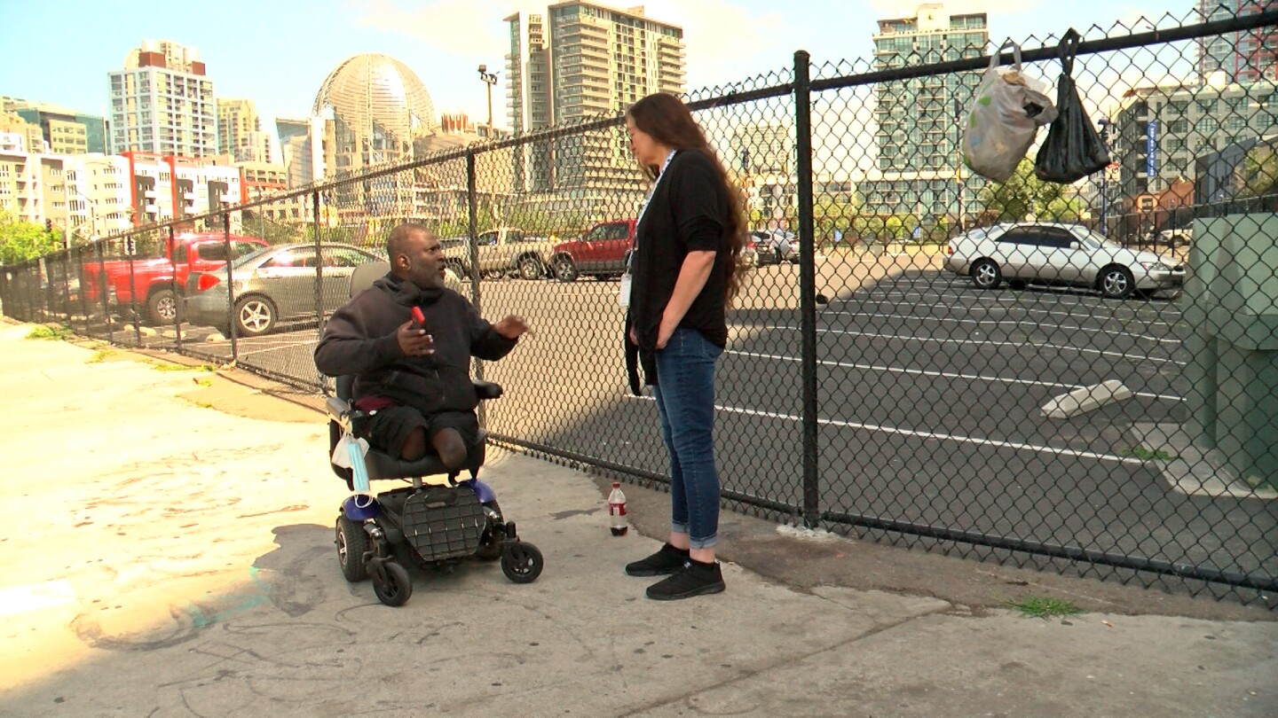 Christina Maria Ennis is shown speaking with fellow St. Teresa resident Maurice Trull outside of the building on May 7, 2025.