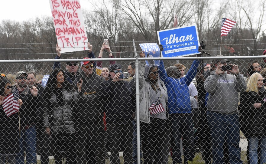 People gather outside Nuss Truck & Equipment in Burnsville, Minn., on April 15 as President Trump arrives for an event to tout his 2017 tax law.