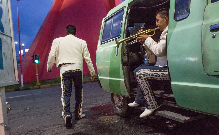 After a fight broke out nearby, Eric Giovani Fabian, 20, plays his trumpet, as his mariachi band, Nuevo Imperio, waits for clients in Mexico City, in August 2017.