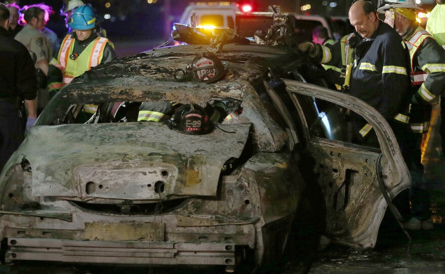 San Mateo County firefighters and California Highway Patrol officers investigate the scene of a limousine fire in which five women died Saturday.